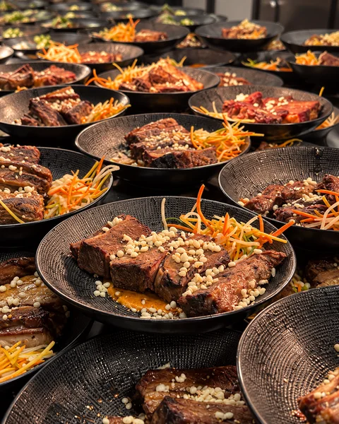 Rows of plated dishes on dark ceramic plates