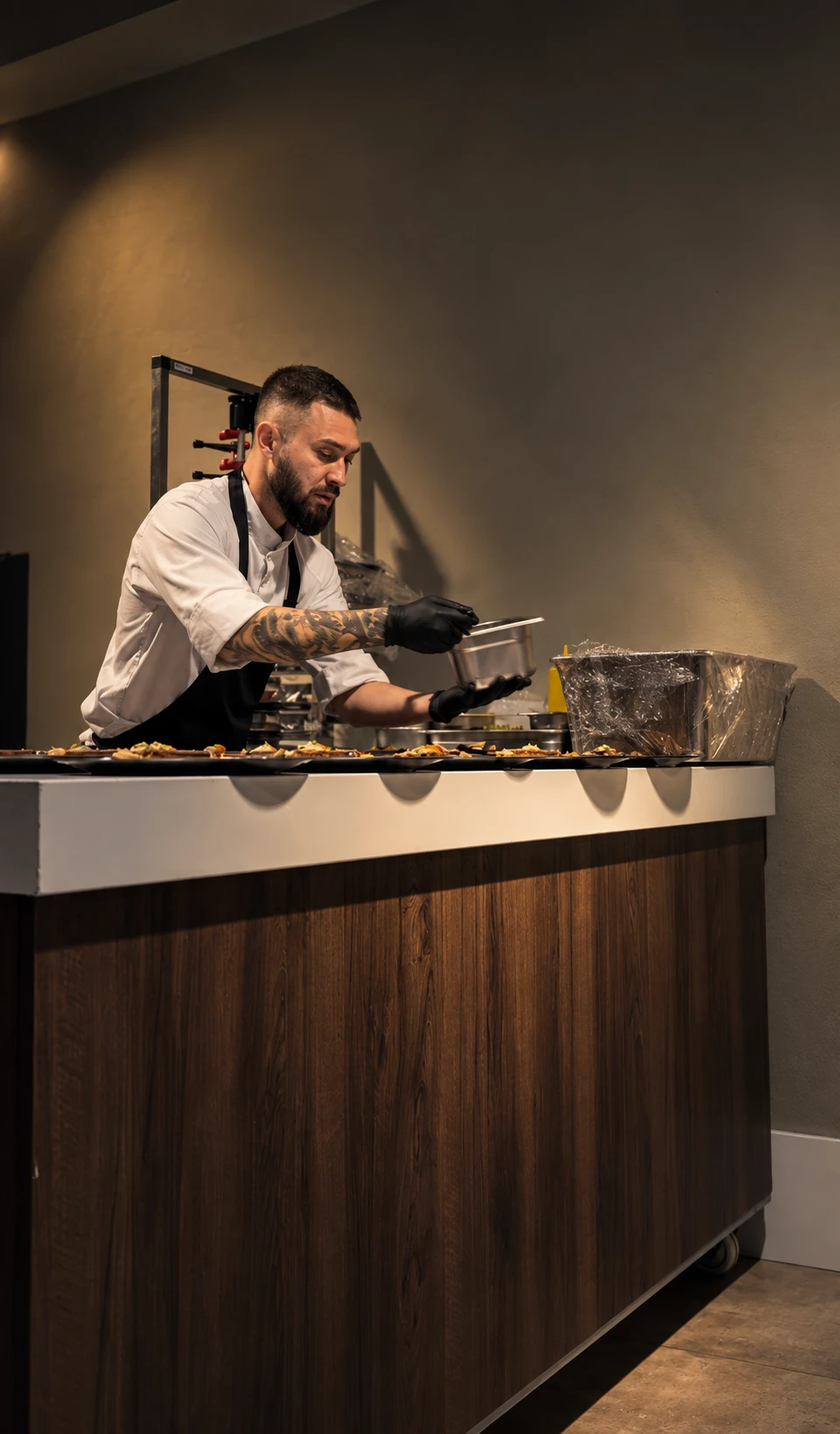 Chef Petre finishing plates behind a kitchen counter.