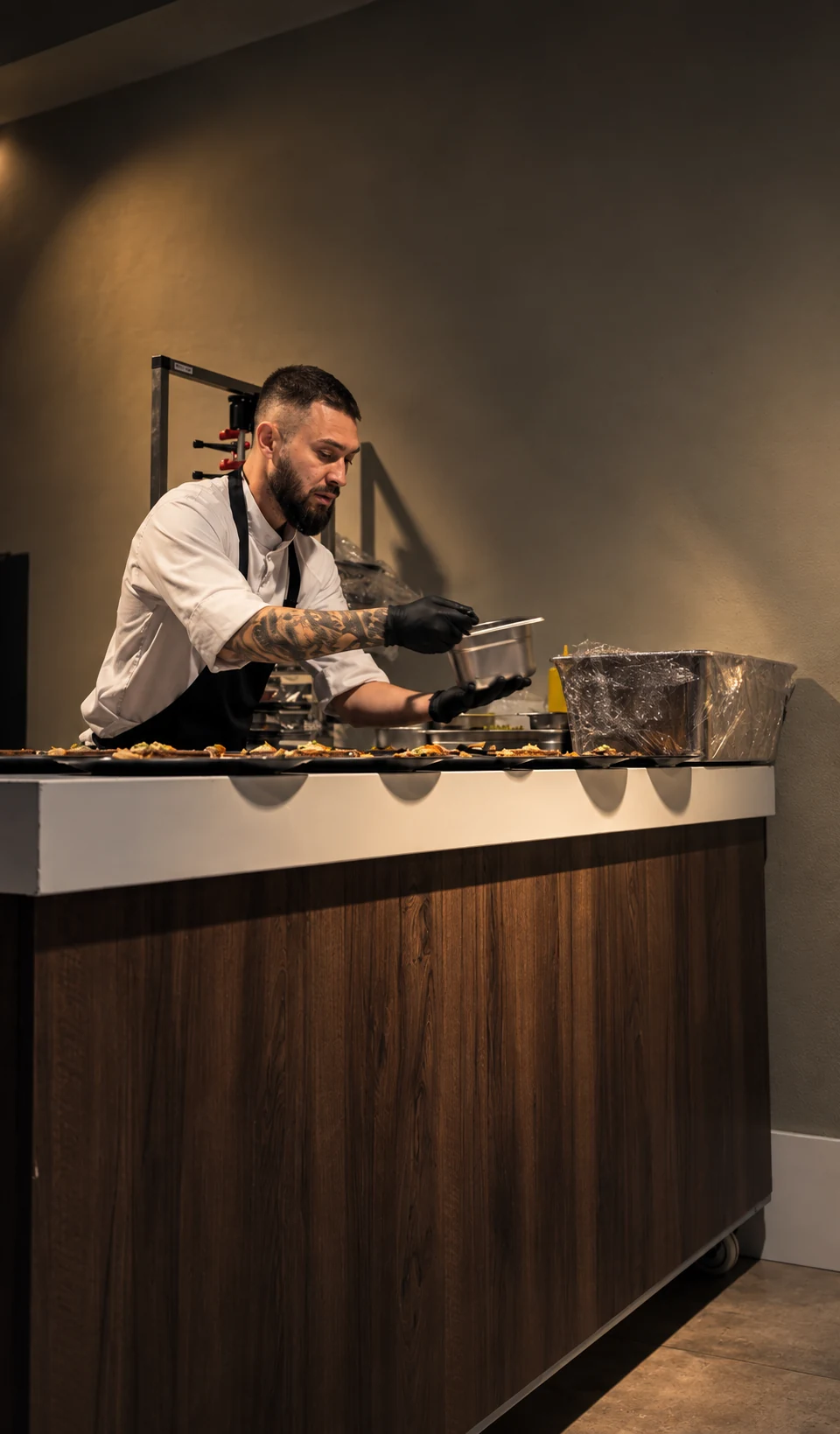 Chef Petre werkt borden af achter een keukenwerkblad.